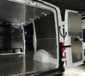 Côté gauche espace de chargement MAN TGE avec plancher et panneaux de protection en aluminium strié et plafond en aluminium